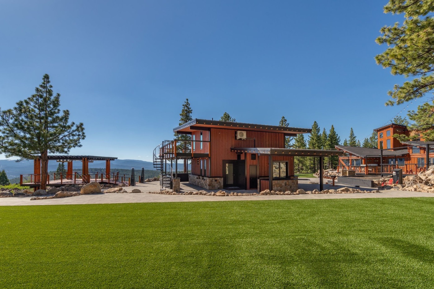 Austin Ridge marketing photo showing the lawn, deck, and surrounding forest.